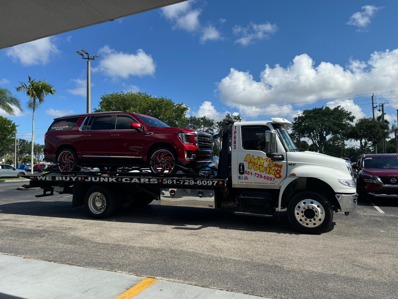 Amy’s flatbed carrying a red SUV